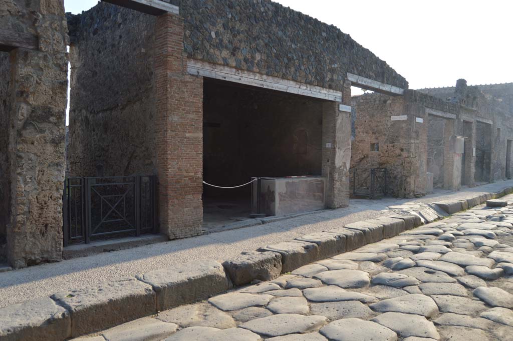 I.8.2, on left, and I.8.1, in centre, next to entrance to Vicolo dell’Efebo. October 2017. 
Looking west along south side of Via dell’Abbondanza.
Foto Taylor Lauritsen, ERC Grant 681269 DÉCOR.
