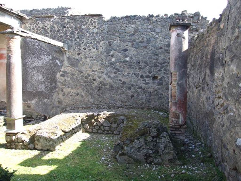 I.8.9 Pompeii. March 2009. Room 9 and Garden area. Triclinium against east wall with two red painted columns built on the couches.
These columns supported a pergola above the triclinium.