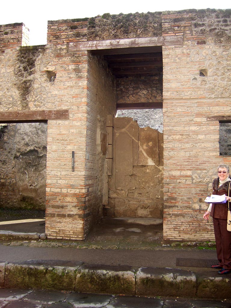 I.9.1 Pompeii. December 2005. Entrance.
According to Boyce, on both walls of the vestibule figures of six divinities had been painted.
The last refashioning of the fa�ade destroyed two of the figures.
On the east wall were Mercury and Hercules, and a missing figure which Della Corte thought was Bacchus.
On the west wall were Minerva and Juno, and traces of a third figure which Della Corte suggested was Venus Pompeiana.
See Notizie degli Scavi di Antichit�, 1913, p. 34.
See Della Corte, M., 1965. Case ed Abitanti di Pompei. Napoli: Fausto Fiorentino. (p.339).
See Boyce G. K., 1937. Corpus of the Lararia of Pompeii. Rome: MAAR 14. (p.110, no.3).

