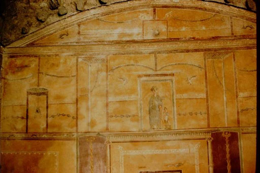 I.9.3 Pompeii. 1957. Room 10. Upper part of the west wall. The upper area was also yellow with a painting of Venus Pompeiana in the centre aedicula. In the side panels of the upper area, were hanging buckets separated by architectural views, garlands, borders with “carpet” pattern, and dolphins in the corners, and holes made by the support beams for the vaulted ceiling. Photo by Stanley A. Jashemski.
Source: The Wilhelmina and Stanley A. Jashemski archive in the University of Maryland Library, Special Collections (See collection page) and made available under the Creative Commons Attribution-Non Commercial License v.4. See Licence and use details.
J57f0116