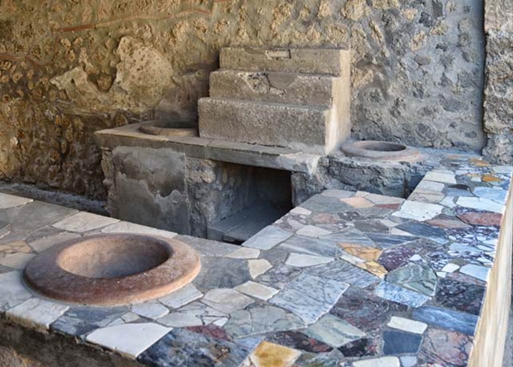 I.9.4 Pompeii. April 2018. Looking towards west wall with display shelving and two urns.
Photo courtesy of Ian Lycett-King. Use is subject to Creative Commons Attribution-NonCommercial License v.4 International.