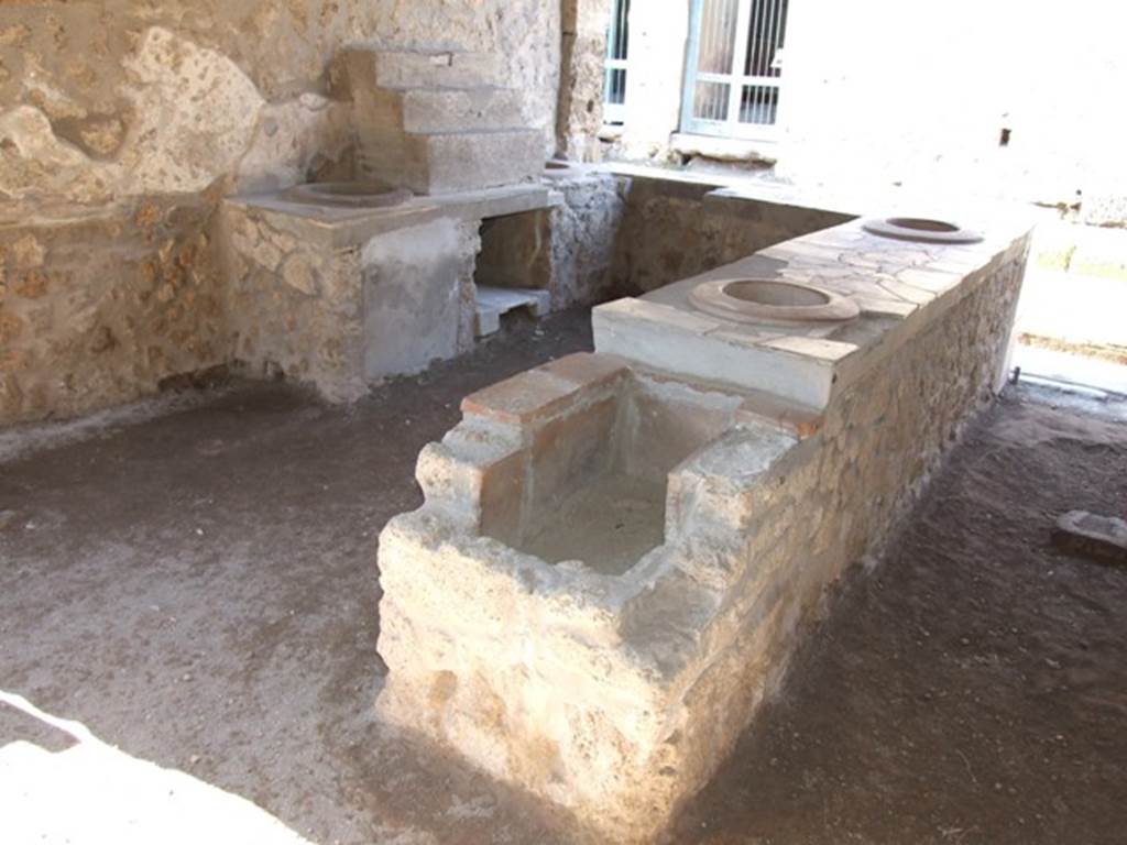 I.9.4 Pompeii. March 2009. Rear view of counter with hearth.