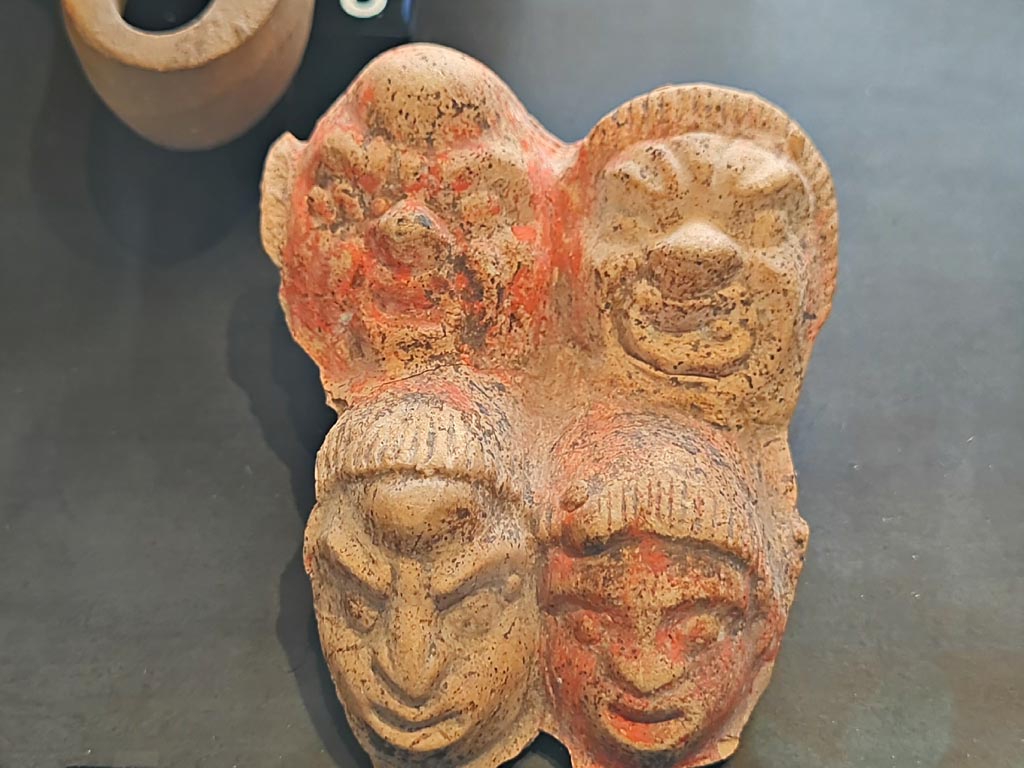 I.9.13/14 Pompeii. March 2024. No 5, detail of Plaque with theatre masks. Photo courtesy of Giuseppe Ciaramella.
On display in exhibition in Palaestra entitled – “L’altra Pompei, vite comuni all’ombra del Vesuvio”.