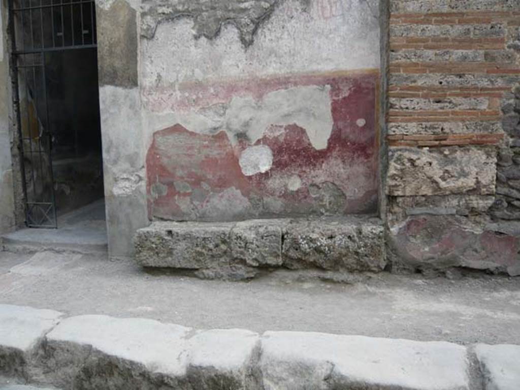 I.10.4 Pompeii. May 2012. Painted plaster on front wall to right of entrance, and faded graffiti. Photo courtesy of Buzz Ferebee.