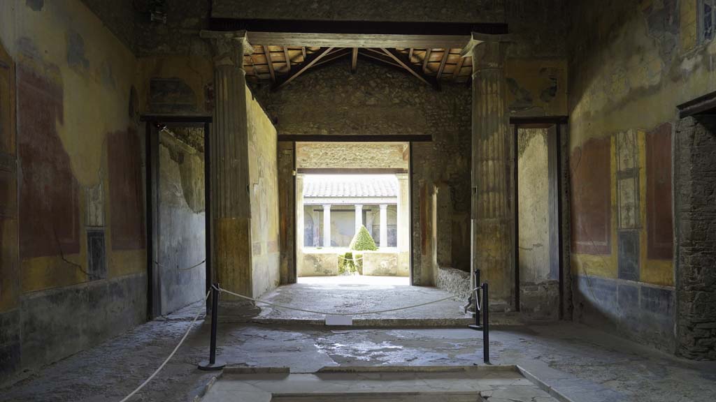 I.10.4 Pompeii. August 2021.
Looking south across impluvium in atrium towards the tablinum, room 8. Photo courtesy of Robert Hanson.
A wood and bronze triclinium bed was found in Room 8, the tablinum, on 18th August 1928.