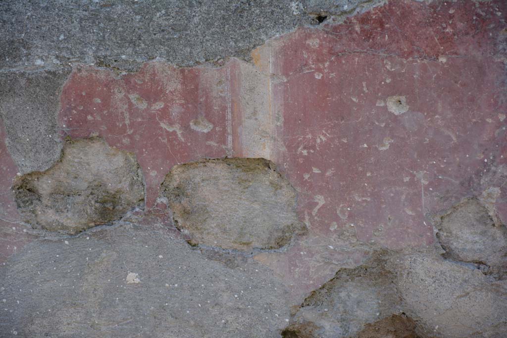 I.10.5 Pompeii. April 2017. Detail of painted plaster on exterior front façade on east side of entrance doorway.
Photo courtesy Adrian Hielscher.