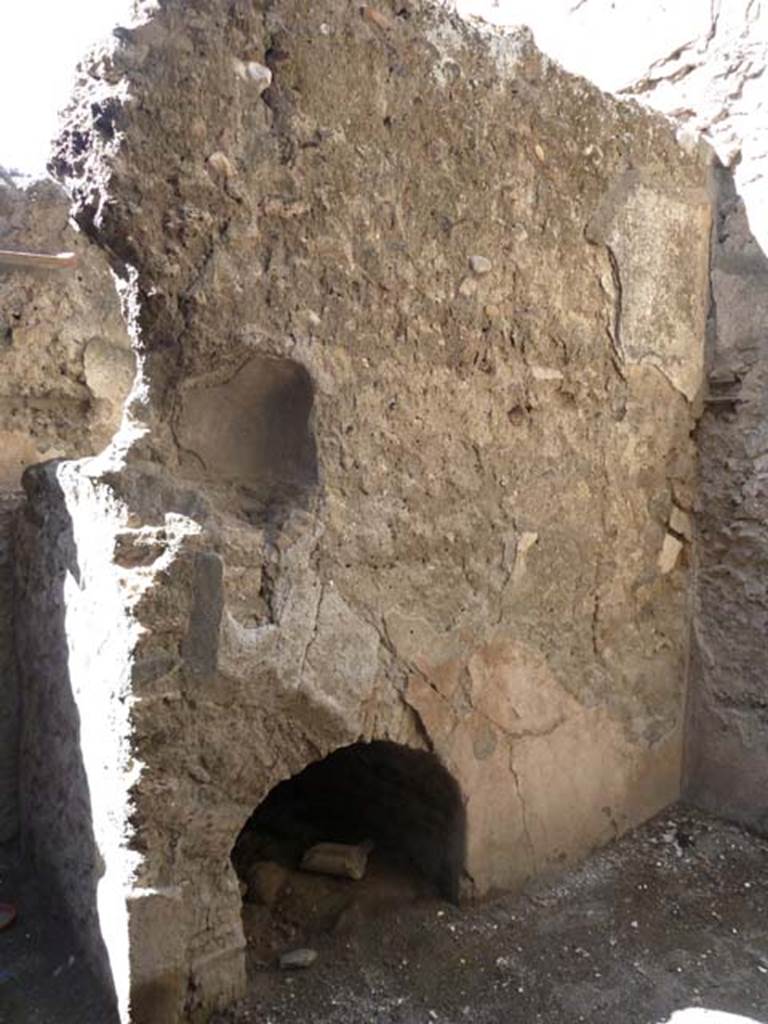 I.10.6 Pompeii. September 2015. In the west wall of the small room to east of the workshop, at a height of 1.45m from the earth, is embedded a small semi-circular lararium niche, 0.33m x 0.43m.
