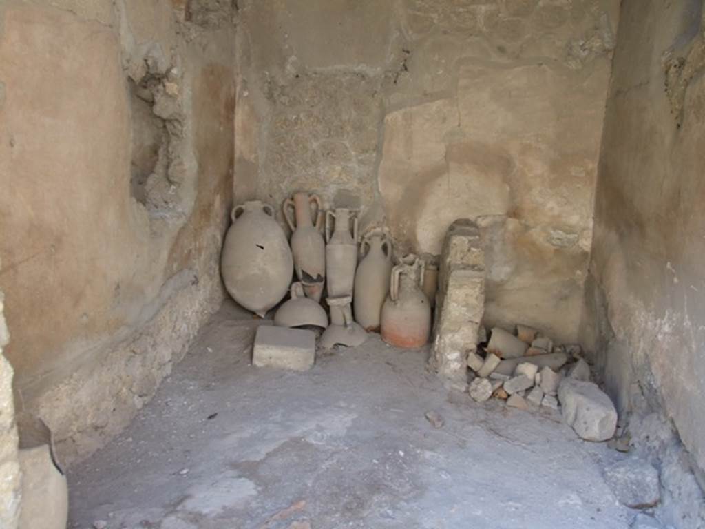 I.10.7 Pompeii. March 2009. Room 1, west wall, with latrine in north-west corner.
According to NdS �
The upper floor: 
Above the west side of the atrium and above the oecus (room 8) would have been a small area of five or six rooms, all more or less decorated in a scheme of the 4th Style.  The upper parts of the walls were preserved only partially for the first 4 rooms nearer to the roadway; all the rest were destroyed and reconstructable only by some traces. The access to this series of rooms would have been by the wooden stairs of room 1, which passed over the top of the latrine but there was also a masonry staircase which led to the walkway above the kitchen,
See Notizie degli Scavi, 1934, (p.292)
