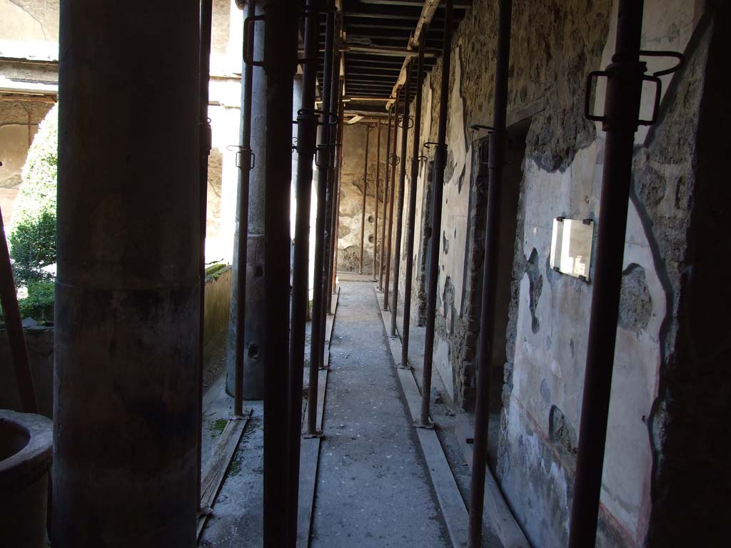 I.10.11 Pompeii. March 2009. Room 10, looking north along east side of portico in peristyle.
The graffito of CIL IV 8408 a – c can be seen on the right side of the photo on the plastered wall.