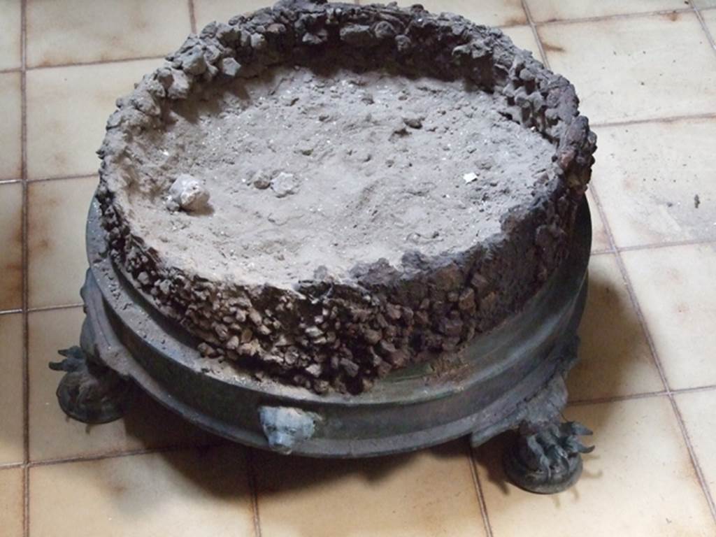 I.10.11 Pompeii. March 2009. Circular decorated brazier. SAP inventory number 20314. One side of the brazier is decorated with the head of a dog and the other with a female face.