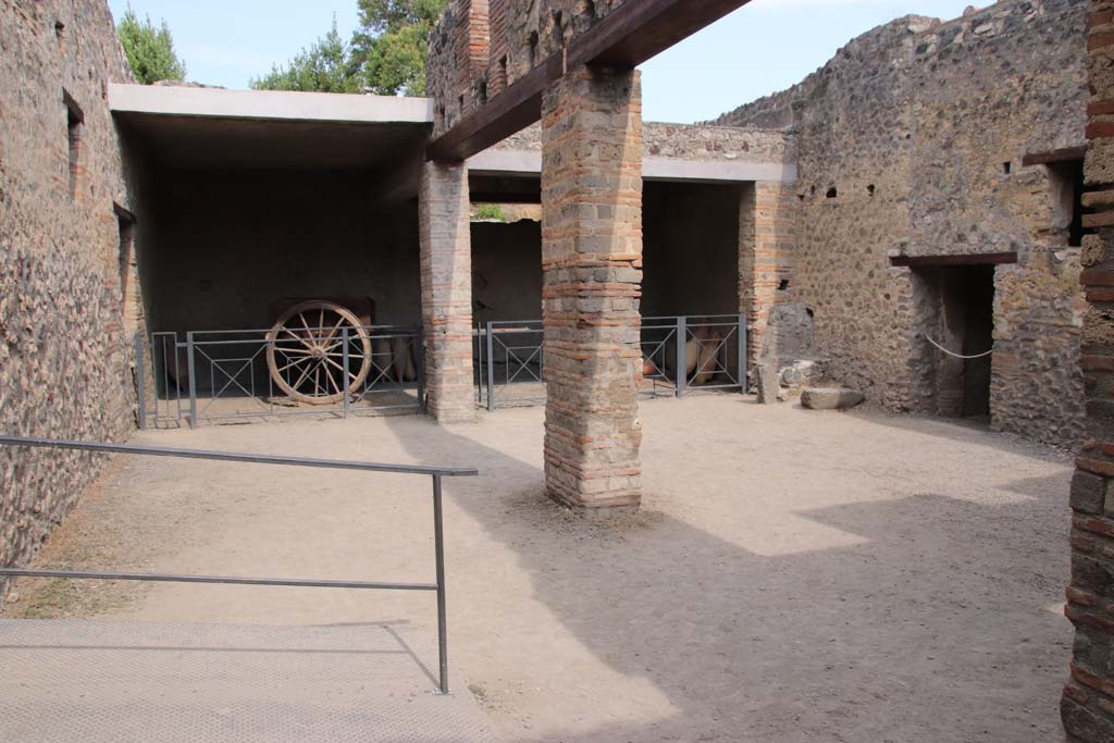 I.10.14, Pompeii. September 2021.
Looking towards east side of stable, with two-wheeled cart and blocked doorway. Photo courtesy of Klaus Heese.