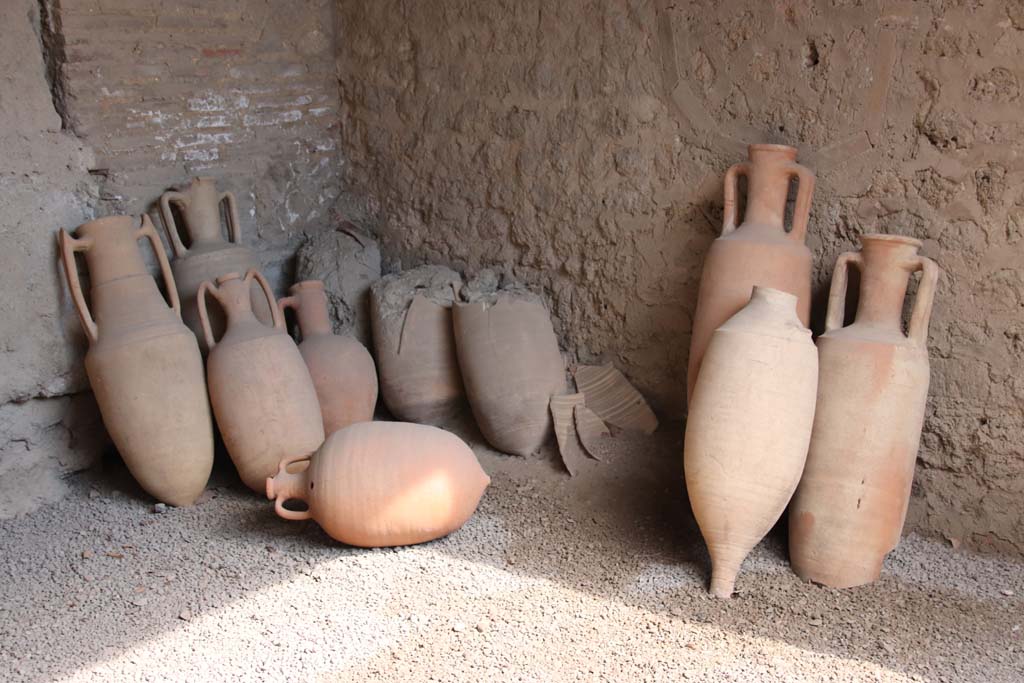 I.10.14, Pompeii. September 2021.
Amphorae in south-east corner, on south side of blocked doorway. Photo courtesy of Klaus Heese.