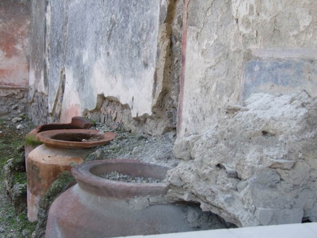 I.11.1 Pompeii. Caupona. West side. Remains of four urns and shelves for displaying drinking vessels.