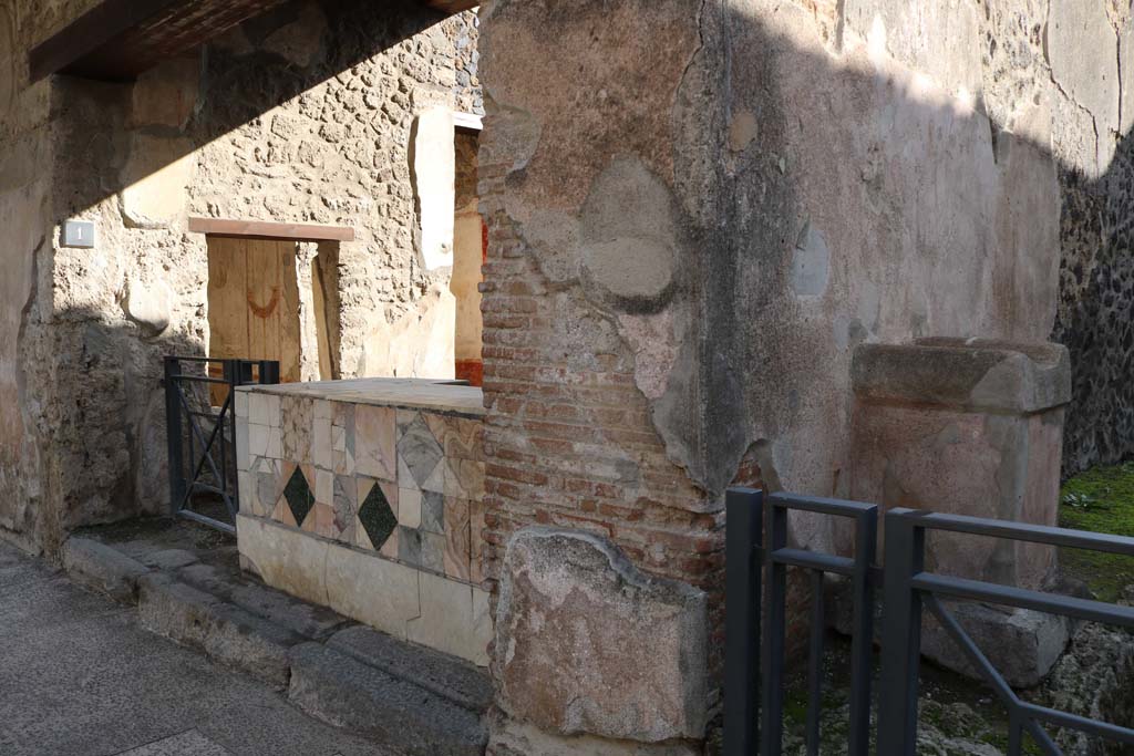I.11.1 Pompeii. December 2018.
Looking south-east towards entrance doorway, on left, and street altar in small roadway, on right. Photo courtesy of Aude Durand.