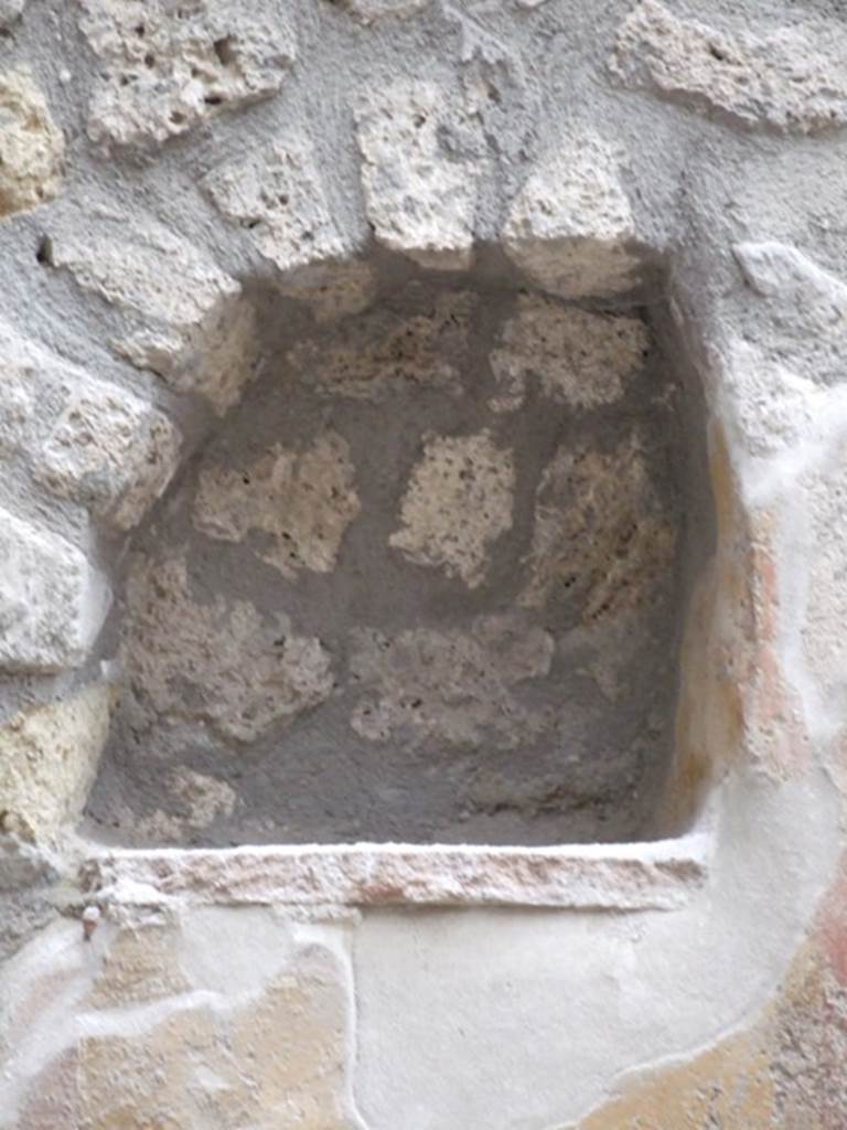 I.11.6 Pompeii. March 2009. Room 6, niche. Arched niche on east side of south wall in garden. According to Giacobello, the niche was found on a wall frescoed in yellow and was part of a painted wall decoration. The niche was made in the last period of the house, when the interior decoration of the garden was done. See Giacobello, F., 2008. Larari Pompeiani: Iconografia e culto dei Lari in ambito domestico. Milano: LED Edizioni. (p.257)