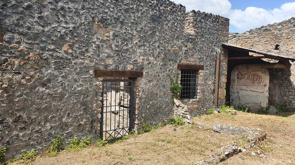 I.11.10 Pompeii. July 2021.
Looking west across small enclosure towards door into bar-room, window into room for the clients, and painted serpent on exterior wall of latrine..
Foto Annette Haug, ERC Grant 681269 DÉCOR.