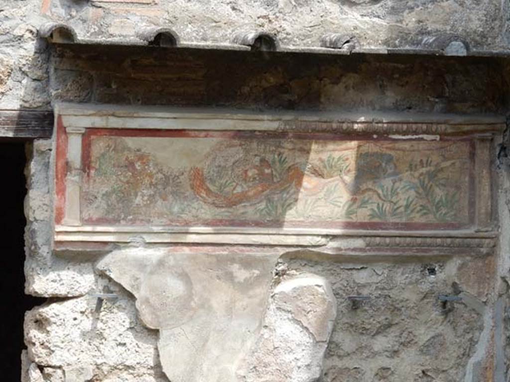 I.11.11 Pompeii. May 2017. Lararium on north wall of thermopolium. Photo courtesy of Buzz Ferebee.
A stucco border surrounding a serpent moving left to a round altar. In the background are green plants with red flowers. See Fröhlich, T., 1991. Lararien und Fassadenbilder in den Vesuvstädten. Mainz: von Zabern. (L21, T:14,1:24,2).