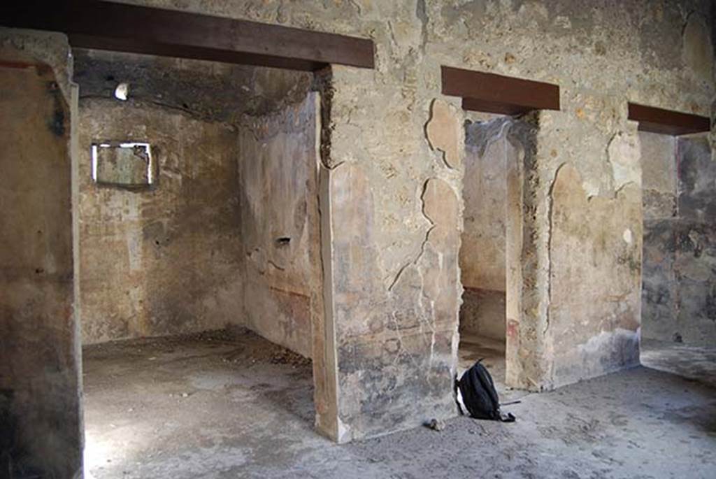 I.11.16 Pompeii. May 2103. Looking north-west across room 3 the covered atrium, towards doorways to rooms 5, 4 and 1. Photo courtesy of Paula Lock. According to Packer, in room 5 (on left), the walls were painted with a purple dado separated from plain yellow walls by a narrow red border. In room 4 (centre right), the walls were painted with a purple dado, set off with a black border, contrasting with plain white walls.