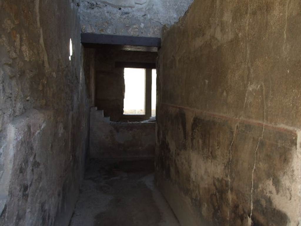 I.11.16 Pompeii. December 2006. Room 1, looking east along entrance corridor.
According to Packer, the fauces was floored with opus signinum, along with all the other rooms (although he stated rooms 10-12 could not be seen because of the rubbish which concealed the floors). The walls were found with a high black dado (zoccolo) with a red border which set off the plain white stucco walls.