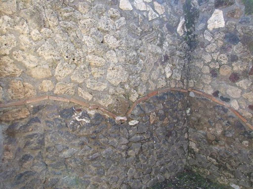 I.12.2 and I.12.1 Pompeii. March 2009. Room 5. South east corner and east wall. The original walls are below the line made from terracotta tiles, above is restored and rebuilt.