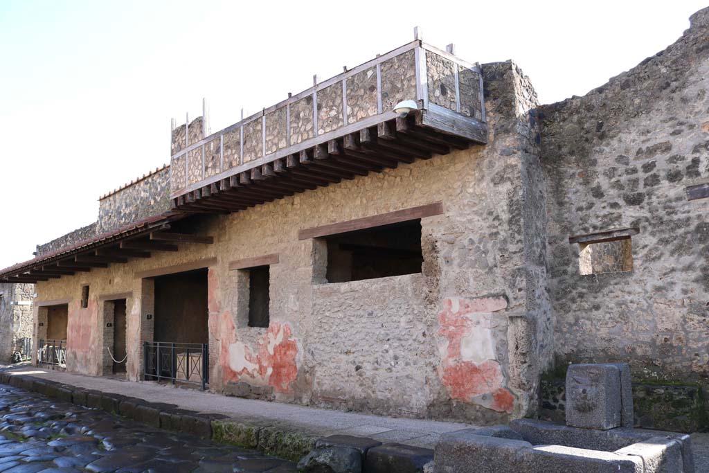 I.12.3 Pompeii. December 2018.
Looking east along south side of Via dell’Abbondanza, between I.12.5 on left, and I.12.3, in centre. Photo courtesy of Aude Durand.