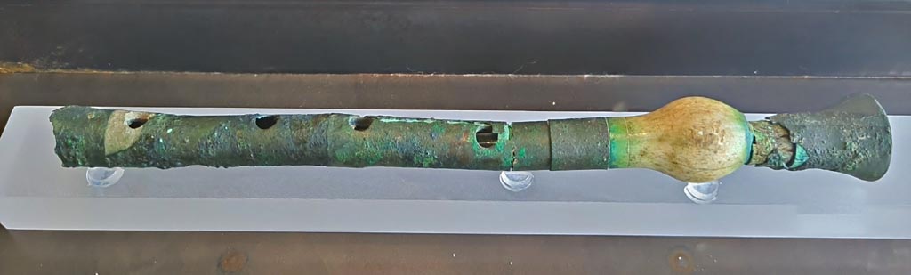 I.12.6 Pompeii. March 2024. Photo courtesy of Giuseppe Ciaramella.
No.10, flute made of bone and sheet bronze. (Ist century AD). (Flauto in osso e lamina do bronzo (I sec. d.C).
On display in exhibition in Palaestra entitled – “L’altra Pompei, vite comuni all’ombra del Vesuvio”.