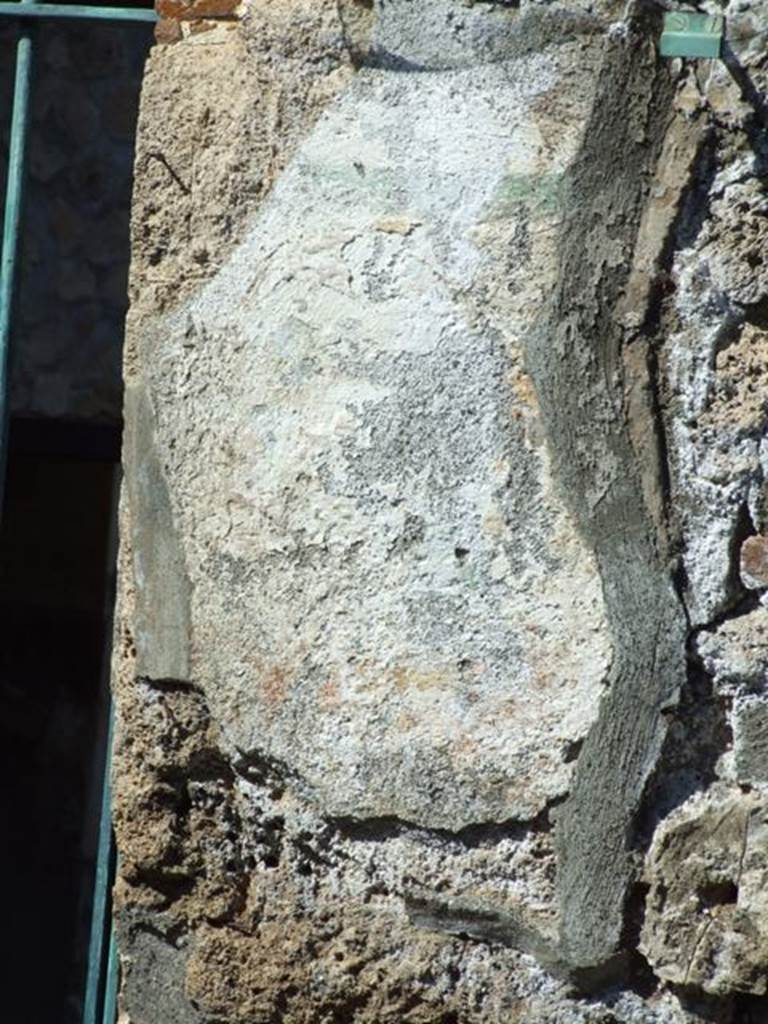 I.12.11 Pompeii. March 2009. Remains of painted plaster on east side of doorway, which was the site of the wall painting of Hercules. The remains of the “garland” are just visible.