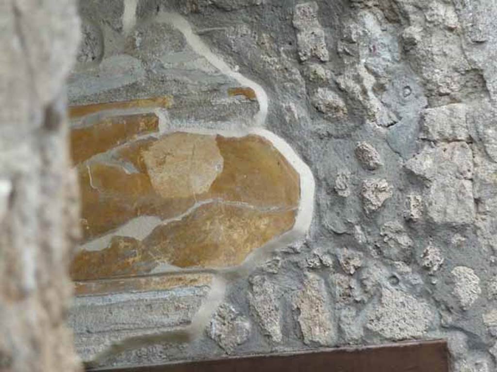 I.13.2 Pompeii. May 2010. Remains of painted wall plaster above small doorway to anteroom, on east side of atrium.