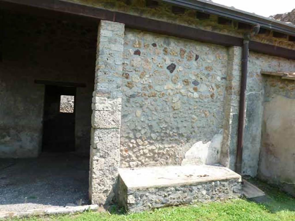 I.13.2 Pompeii. May 2010. East wall of garden with a long masonry bench built between the 2 pilasters in the east wall and doorway to kitchen.