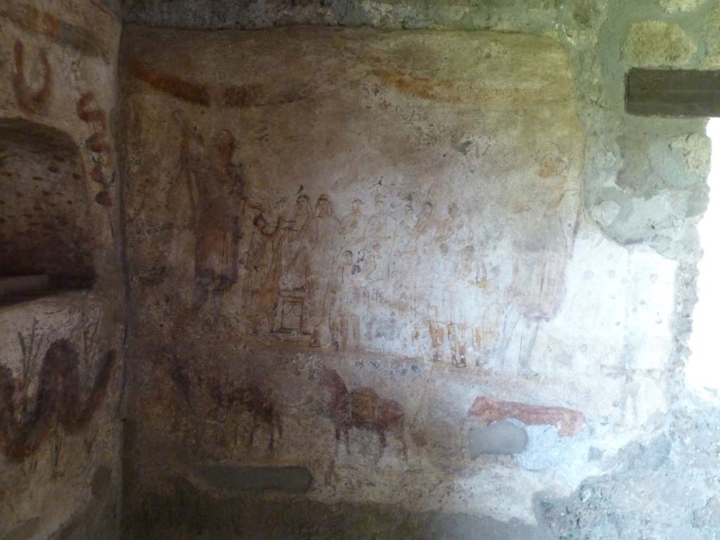 I.13.2 Pompeii. May 2010.
East wall of kitchen with lararium painting showing the matron of the house with her entire family offering sacrifice at the Caristia, a ritual celebrating family and held on February 22. (Fig 35.1 on page 541).
See Dobbins, J & Foss, P., 2008. The World of Pompeii. New York: Routledge. (p.534)