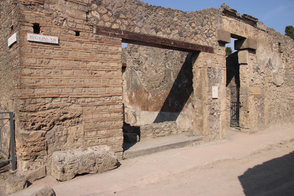 I.13.13 Pompeii, in centre, and I.13.12, on right. October 2023.
Looking towards entrance doorways on north side of Via di Castricio. Photo courtesy of Klaus Heese.