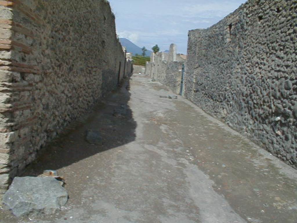 I.12 Pompeii. September 2004. Vicolo dei Fuggiaschi looking north.Side wall of I.13.13