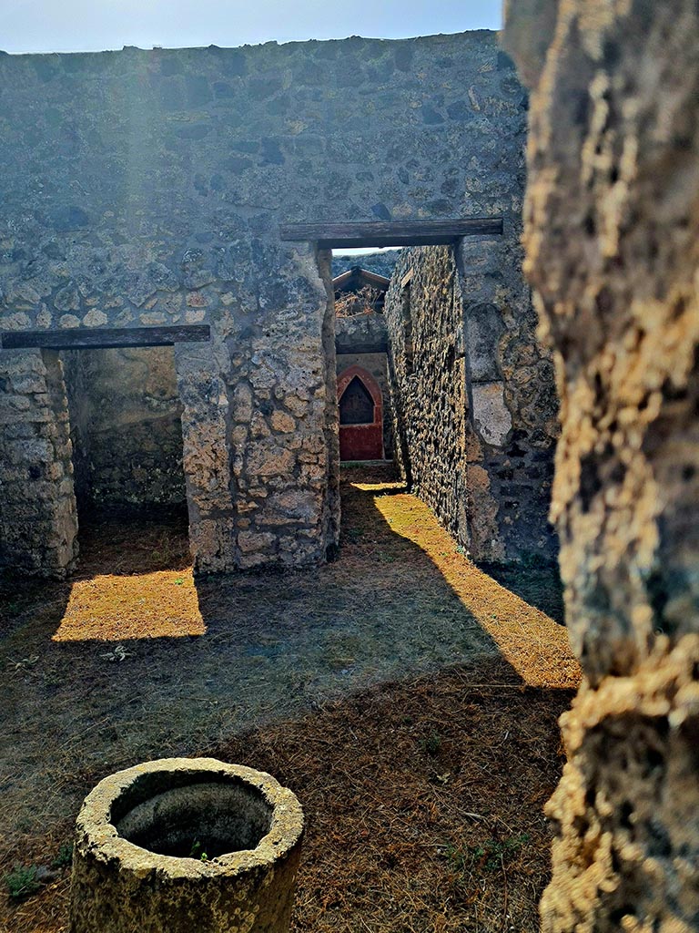 I.14.6/7 Pompeii. September 2024.
Looking south into atrium of I.14.7 from doorway of shop at I.14.6. Photo courtesy of Giuseppe Ciaramella.