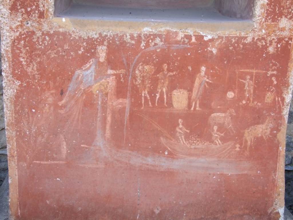 II.14.7 Pompeii. March 2009. Base of Lararium. The River God Sarnus is shown pouring water into the river , and overlooking the busy activity at the harbour. This includes produce being delivered and weighed, of donkeys and mules carrying goods to and from barges, and a boat loaded with produce.