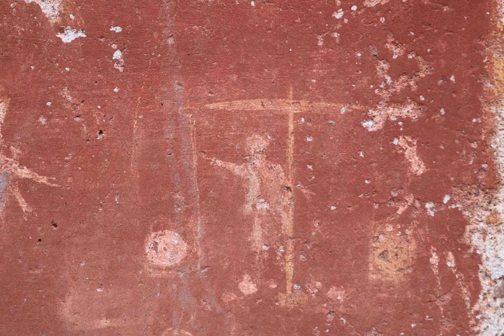 I.14.7 Pompeii. December 2018. Detail from base of lararium.
Two men in short robes weighing two baskets on large weighing scales. Photo courtesy of Aude Durand.