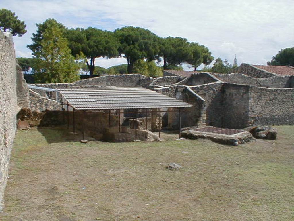 I.14.10 Pompeii. September 2004. Looking east towards the triclinium, the inspection shaft of the Sarno Canal and the entrance to I.14.4.