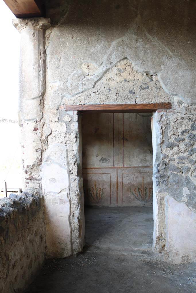 .14.12 Pompeii. December 2018.
Doorway to room 2 on east side of peristyle, and north end of room 32, east portico, taken from I.14.13.
Photo courtesy of Aude Durand.