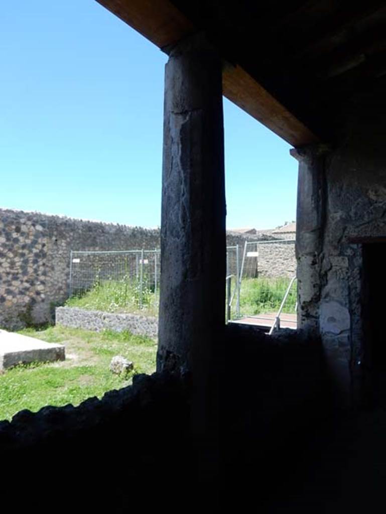 I.14.12, Pompeii. May 2018.
Room 32, looking north-west across east portico, with pluteus (wall of peristyle built between columns) towards adjoining garden of I.14.1.
Taken from near doorway to room 2, on right. Photo courtesy of Buzz Ferebee