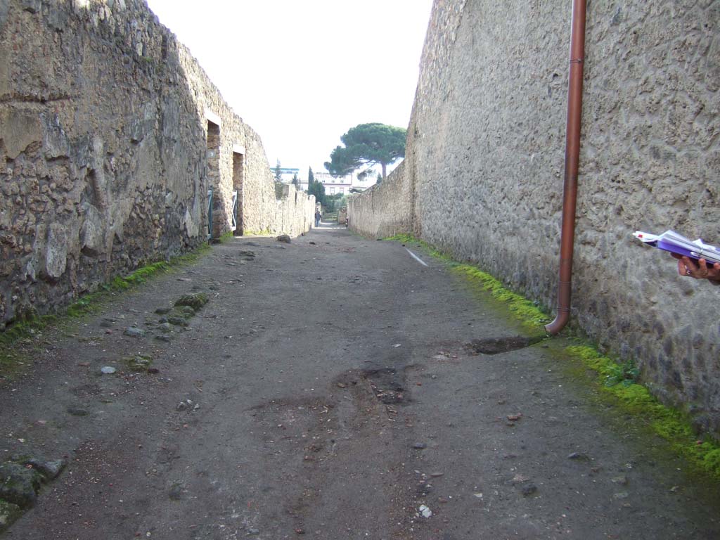 I.14 Pompeii, on left. December 2005. Roadway looking south. I.15.1 Side wall, on right.