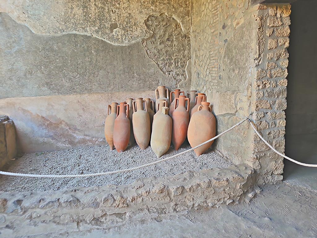 I.15.3 Pompeii. September 2024.
Tub or basin on east end of south portico 10 of peristyle 13 with amphorae. Photo courtesy of Giuseppe Ciaramella.