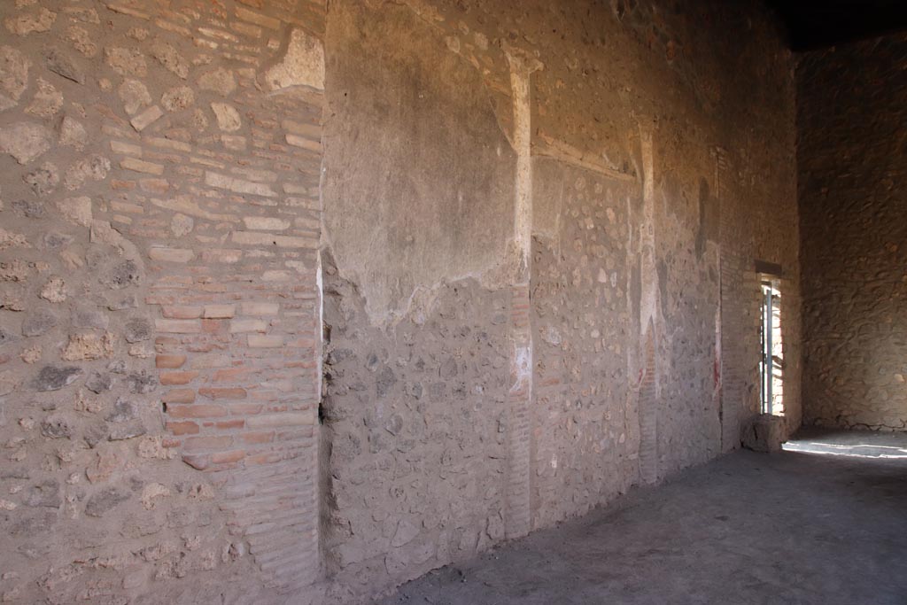 I.15.3 Pompeii. October 2022.
Looking east along south wall of south portico 10, towards doorway into room 14, garden area. Photo courtesy of Klaus Heese.