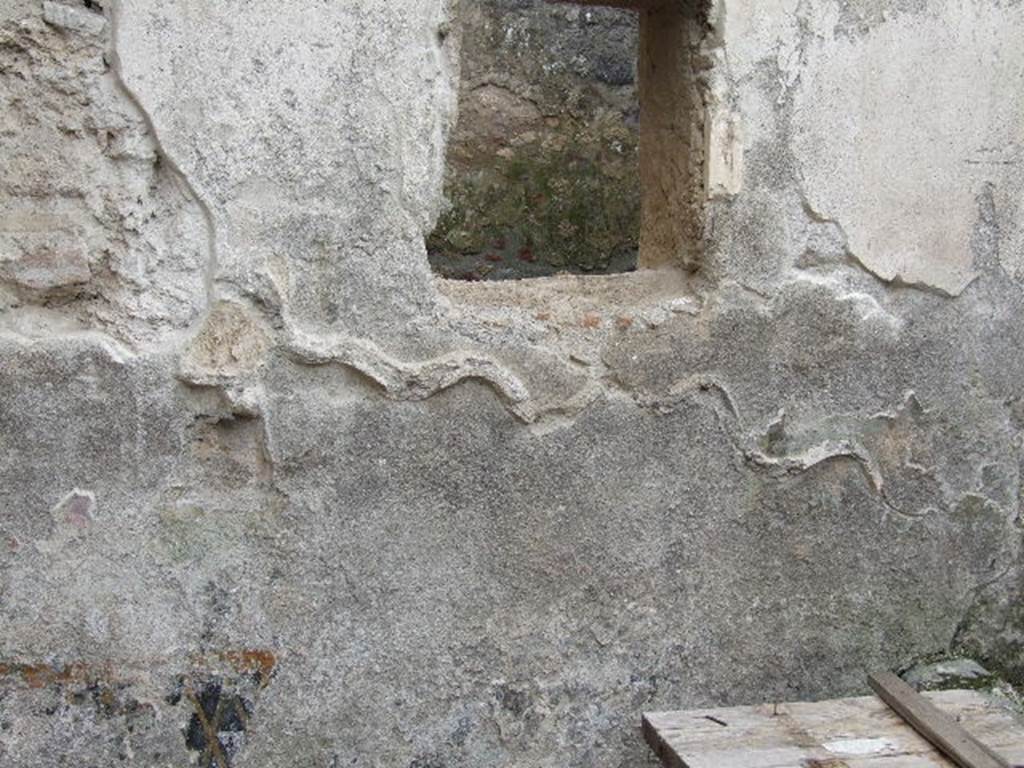 I.16.3 Pompeii. December 2006. South wall of rectangular area, garden or pool? Remains of a serpent, and with a small altar below the head of the serpent, both in stucco relief. According to Giacobello, in stucco on the south wall a serpent slides towards an altar. The scene was placed on the inside of a picture of a garden, today vanished, with plants, flowers and birds. Behind the decorated wall one finds a basin with well and a flowerbed in front. See Giacobello, F., 2008. Larari Pompeiani: Iconografia e culto dei Lari in ambito domestico. Milano: LED Edizioni. (p.234)