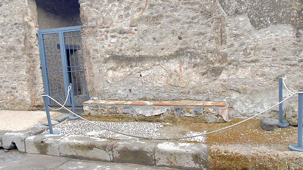 I.16.3 Pompeii, on left. July 2021. Looking south towards entrance doorway on Via di Castricio.
On the west side of the doorways on the exterior wall, are the remains of decorated plaster, and a bench. 
Foto Annette Haug, ERC Grant 681269 DÉCOR. 
