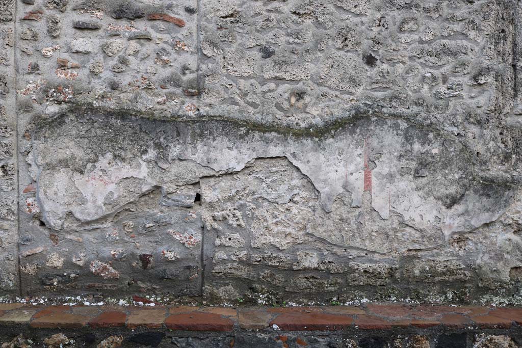 I.16.3 Pompeii. December 2018.
Front façade wall on west of entrance doorway, remains of painted plaster decoration. Photo courtesy of Aude Durand.