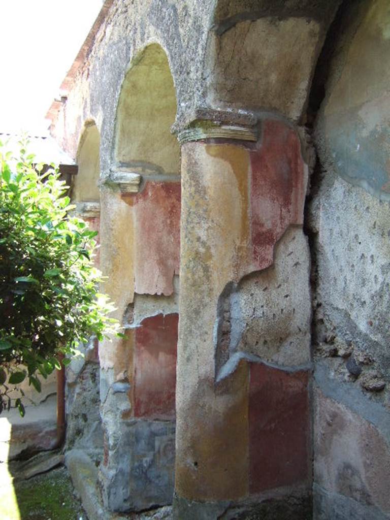 I.17.4 Pompeii. May 2006. East wall of peristyle garden. Pillars, columns and arches built into the wall.