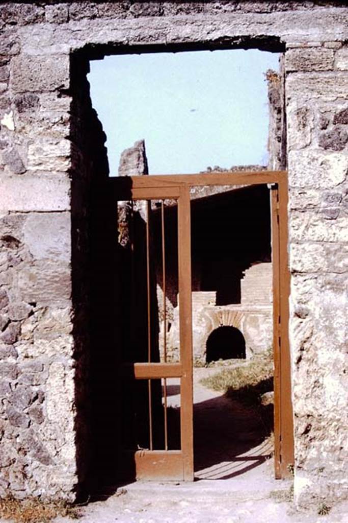 I.20.3 Pompeii. 1972. Entrance doorway. Photo by Stanley A. Jashemski.
Source: The Wilhelmina and Stanley A. Jashemski archive in the University of Maryland Library, Special Collections (See collection page) and made available under the Creative Commons Attribution-Non Commercial License v.4. See Licence and use details. J72f0110
According to Wilhelmina, writing about a hole discovered in the garden of I.15.3,
“When the heavy growth had been cleaned from the hole, it was noticed that the hole had a yellow colour, which it was thought may have been potter’s clay, but of a quality that would have required much work to refine it. It may have been the source of the clay used at the nearby lamp and dice box factory. Prof. Cerulli Irelli had taken them to see this small factory which she had been studying. The moulds in which the lamps were made, the finished lamps, and the kiln in which they would have been fired were all seen. The lamps had all types of decoration such as deities, birds and plants. Wilhelmina especially liked the one of a small cupid trudging along, carrying two huge baskets of produce, perhaps grapes, hanging from a pole resting on his shoulders.”
See Jashemski, W.F., 2014. Discovering the Gardens of Pompeii: Memoirs of a Garden Archaeologist, (p.189-192????)