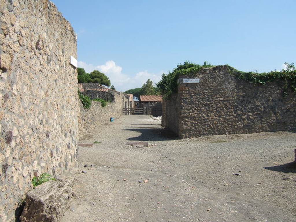 I.16 Pompeii, and I.15 (ahead). Via della Palestra, looking east . Side wall of I.21.1