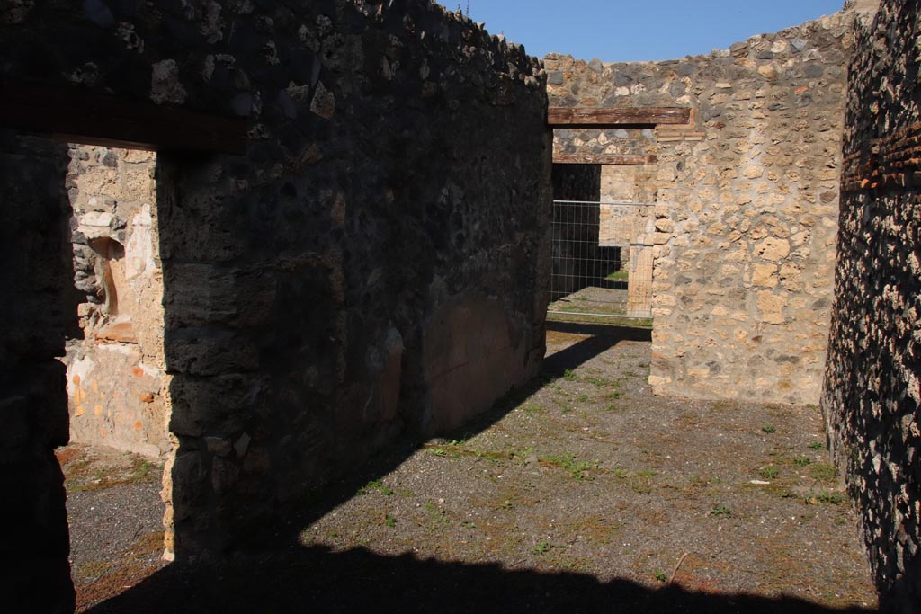 I.21.5 Pompeii. October 2022.
Looking towards west wall in rear room with doorway to garden area, on left, and north to doorway to atrium, in centre.
Photo courtesy of Klaus Heese.