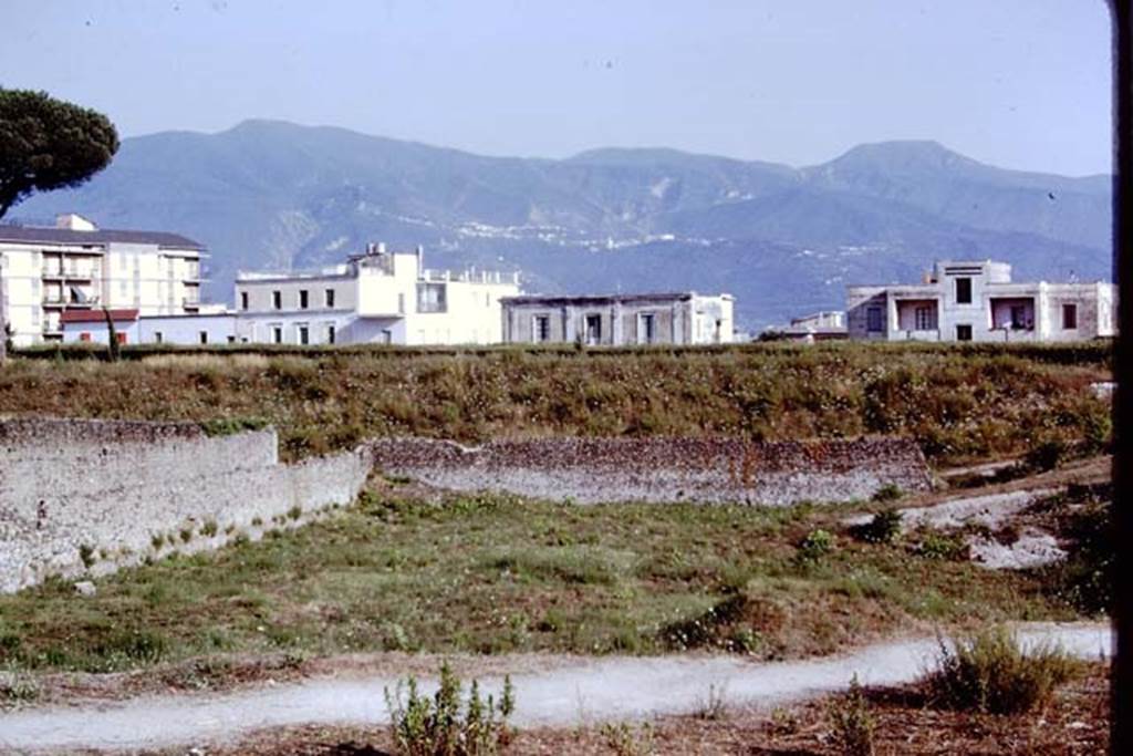 I.22 Pompeii. 1972. Looking south. Photo by Stanley A. Jashemski.
Source: The Wilhelmina and Stanley A. Jashemski archive in the University of Maryland Library, Special Collections (See collection page) and made available under the Creative Commons Attribution-Non Commercial License v.4. See Licence and use details. J72f0575
According to Wilhelmina, by 1964 most of the lapilli had been removed by the original excavators (1959-60). As this had been the last insula excavated, it had not been possible to excavate it completely to the west wall, due to the pressure of soil from the other side. Even so, she was still able to find about 150 tree-root cavities in the part of the area that they could search through (approximately 50% of it). This was to be the first large orchard found within the city itself.
See Jashemski, W. F., 1993. The Gardens of Pompeii, Volume II: Appendices. New York: Caratzas. (p.73)