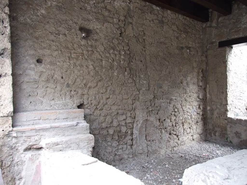 II.1.1 Pompeii. December 2006. Counter and east wall.
In the south-east corner there was a niche of a lararium to Venus which is no longer visible.
In the 1917 photo of the entrance when first excavated, see above near beginning of photos, the niche can clearly be seen.
See Spinazzola in Notizie degli Scavi di Antichità, 1917, (p.252, fig.5)
According to Boyce, the arched niche on the east wall had a painted blue border.
In front of it stood a small table decorated with metopes.
Nothing was found in the niche, but when the soil under the niche was investigated, fragments of a pseudo-alabaster statuette of Venus was found.
It was of very rough workmanship but had been gilded originally.
In front of the image of the goddess stood a small altar of terracotta.
See Boyce G. K., 1937. Corpus of the Lararia of Pompeii. Rome: MAAR 14. (p. 30, no. 61)
Boyce gives a reference to Not. Scavi 1917, 251, with a photograph of the statuette, on p. 253.